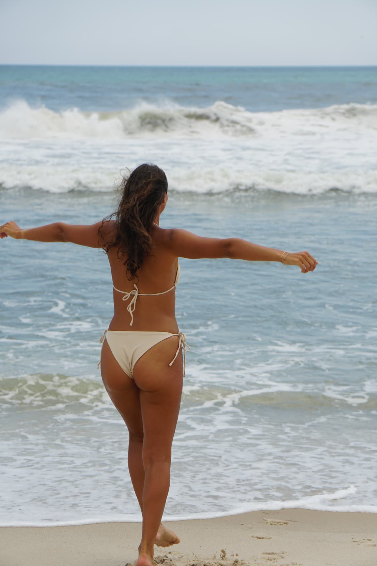 Back view of the Coconut bikini walking toward the water